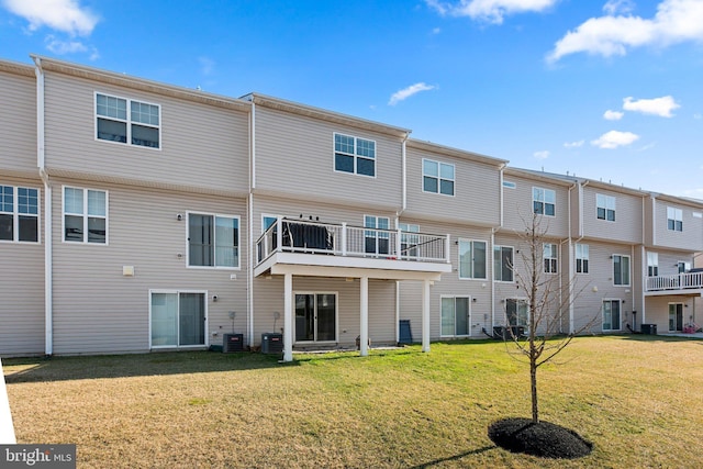 back of property with a lawn and central AC