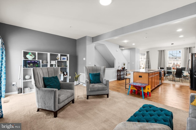 living area with recessed lighting, baseboards, light wood finished floors, and light carpet