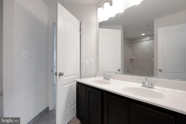 full bath with double vanity, a sink, tile patterned floors, and walk in shower