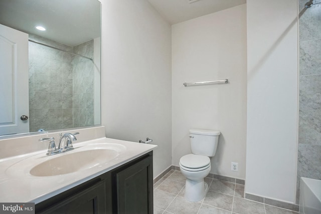 bathroom with vanity, toilet, baseboards, tile patterned floors, and a bathtub