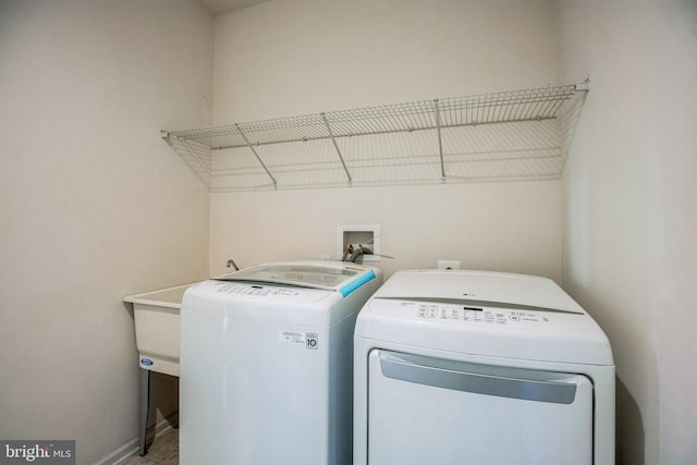 laundry area with baseboards, laundry area, and separate washer and dryer