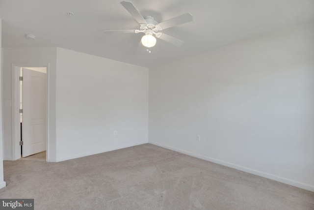 carpeted spare room with baseboards and ceiling fan