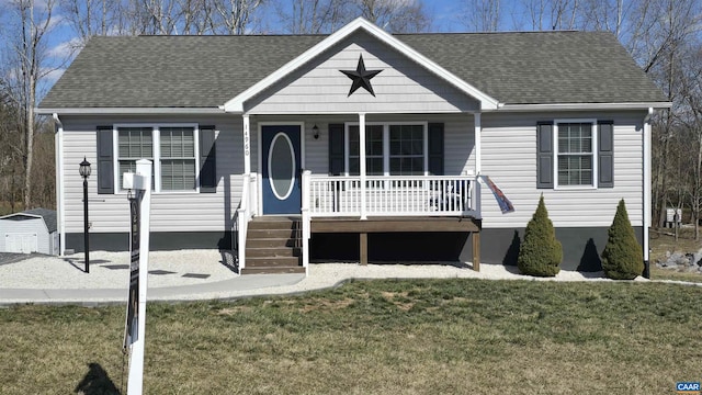 bungalow with covered porch, a shingled roof, and a front lawn