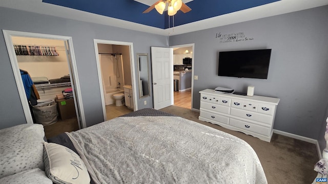 bedroom with a closet, baseboards, connected bathroom, a raised ceiling, and a spacious closet