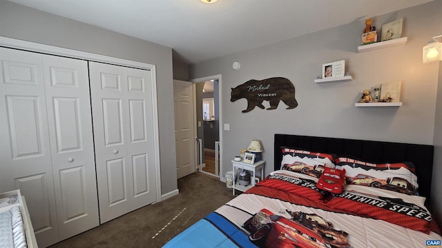 bedroom with a closet, baseboards, and dark colored carpet