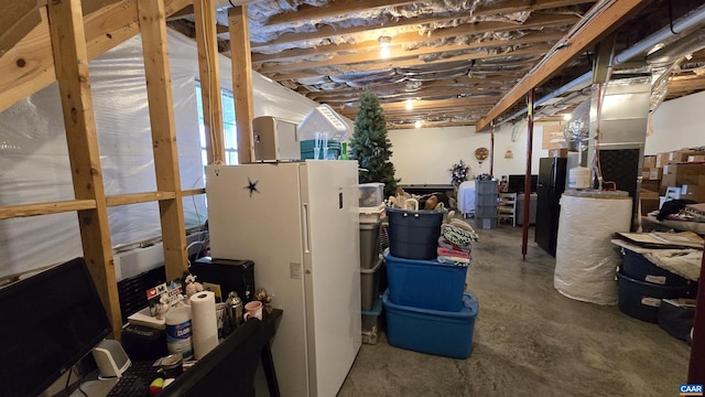 unfinished basement with freestanding refrigerator