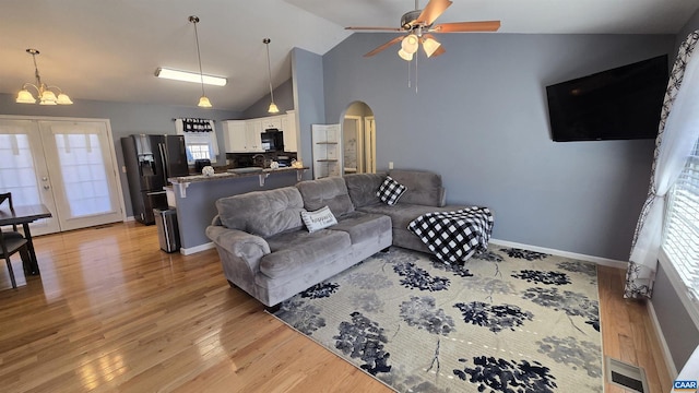 living room featuring visible vents, french doors, arched walkways, light wood-style floors, and baseboards