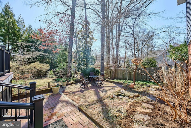 view of yard featuring outdoor dining space, a patio area, and fence