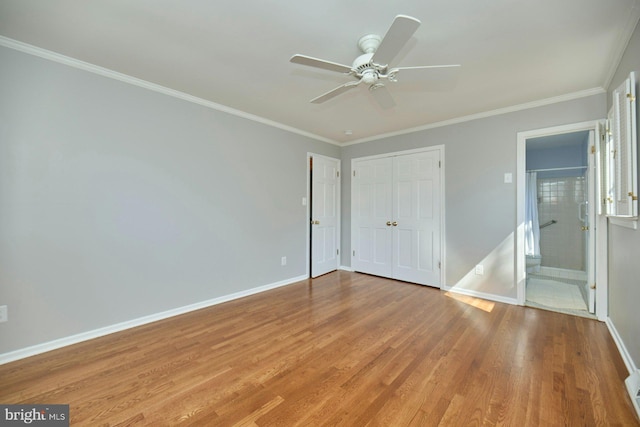 unfurnished bedroom with wood finished floors, a closet, crown molding, baseboards, and ceiling fan