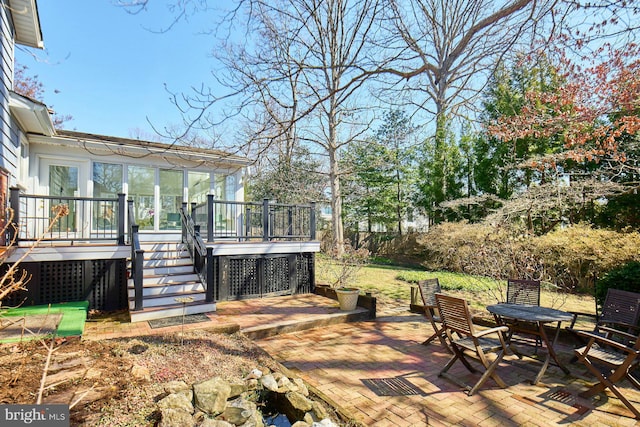 view of patio with a deck, stairs, and fence