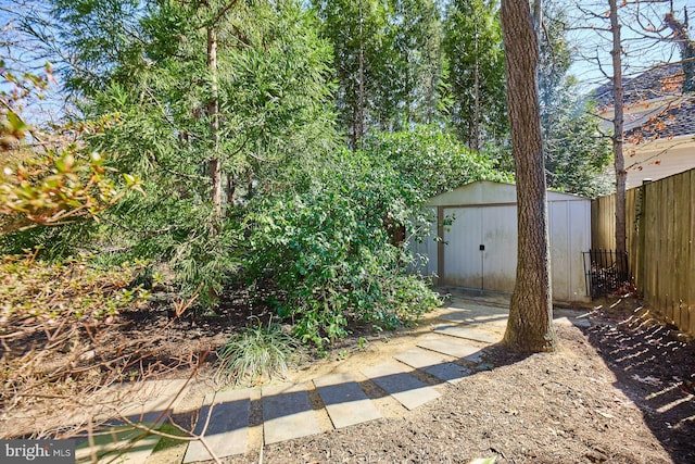 view of yard with a storage shed, fence, and an outdoor structure