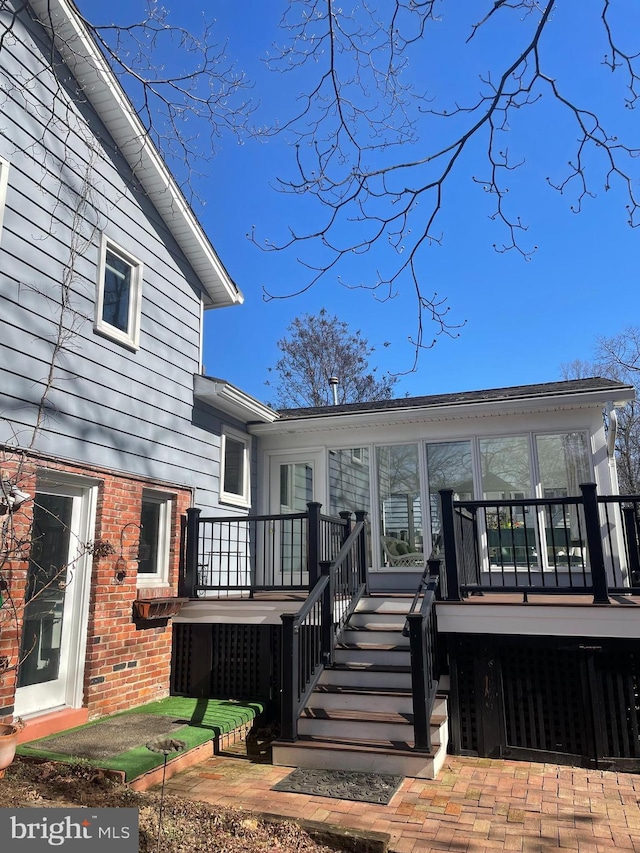 exterior space with a wooden deck and brick siding