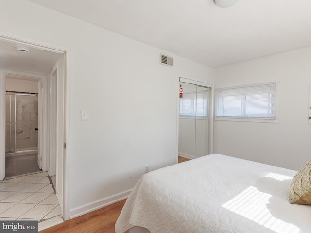 bedroom featuring visible vents, baseboards, a closet, and light wood-style flooring