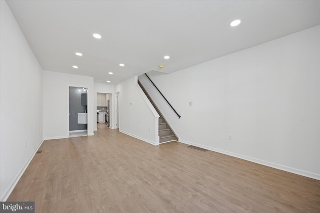 unfurnished living room with stairs, recessed lighting, visible vents, and light wood finished floors