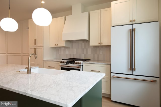 kitchen featuring backsplash, high quality appliances, custom range hood, and a sink