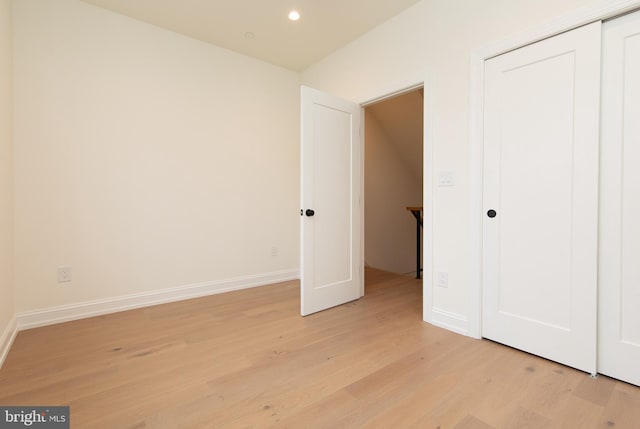 unfurnished bedroom featuring a closet, recessed lighting, light wood-style flooring, and baseboards