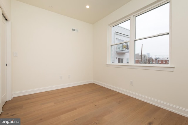 unfurnished room with light wood-style flooring and baseboards