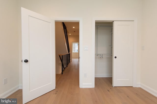 unfurnished bedroom featuring a closet, recessed lighting, baseboards, and light wood-style floors