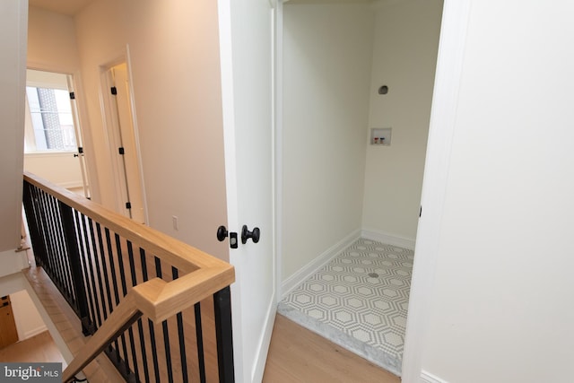 staircase featuring baseboards and wood finished floors