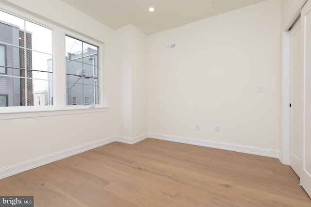 empty room with recessed lighting, light wood-style flooring, visible vents, and baseboards