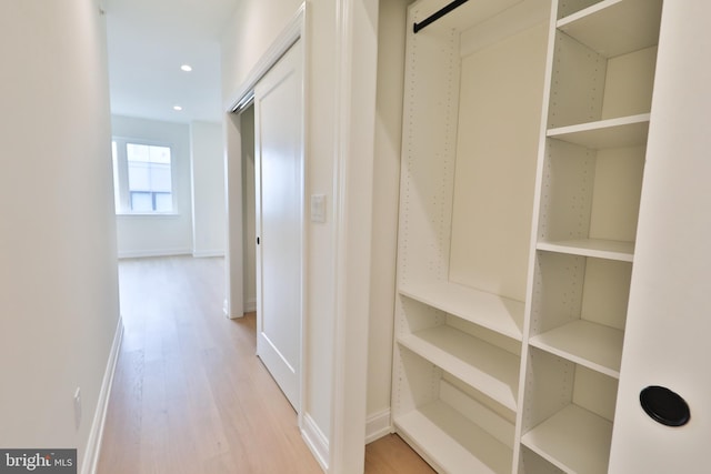 hall featuring recessed lighting, light wood-type flooring, and baseboards