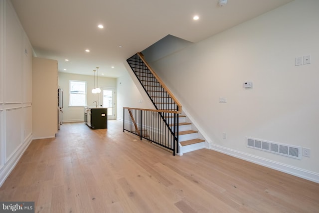 interior space with visible vents, recessed lighting, light wood-style floors, and a sink