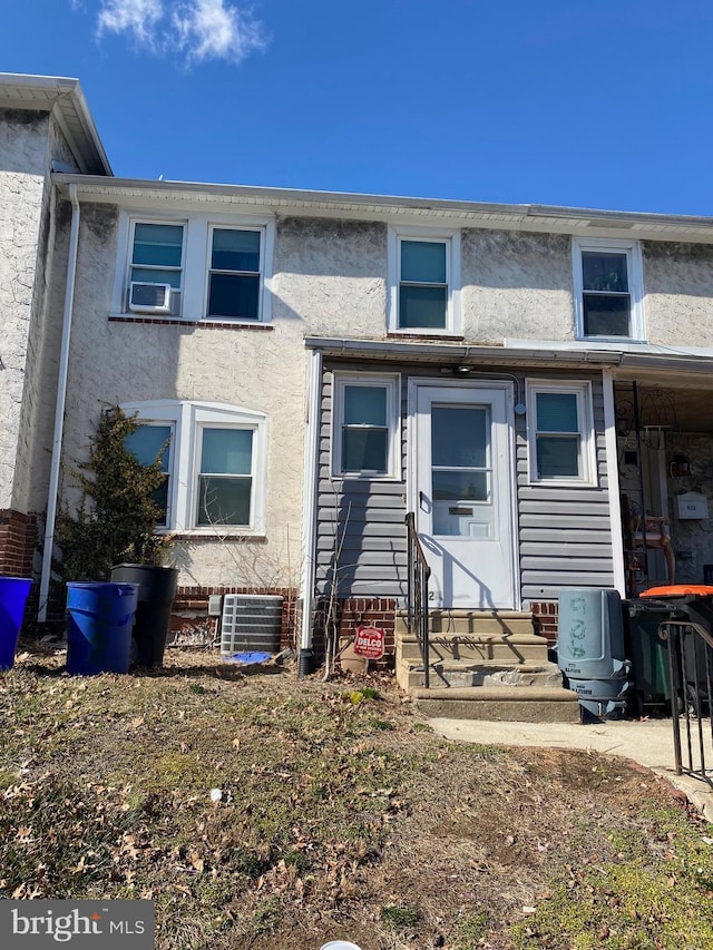 view of property featuring cooling unit, stucco siding, and entry steps