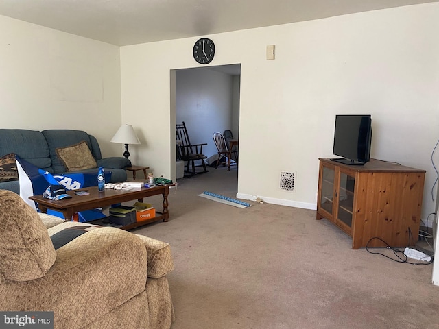 living area with visible vents, baseboards, and carpet