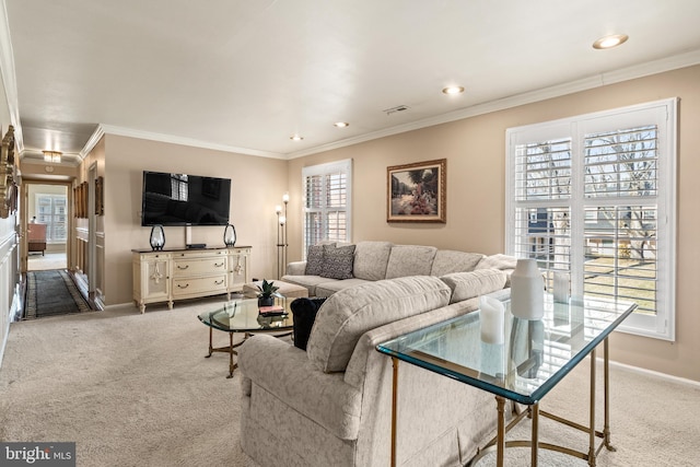 living area featuring a wealth of natural light, carpet flooring, and ornamental molding