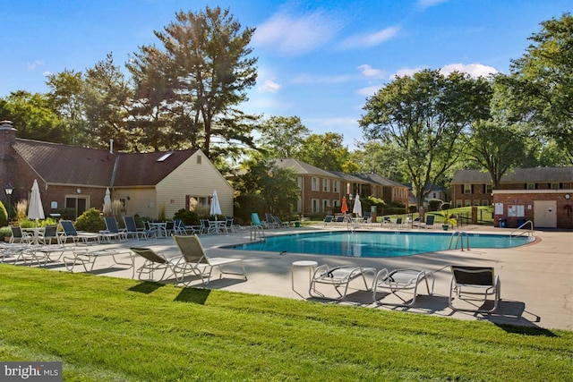 community pool featuring a lawn and a patio