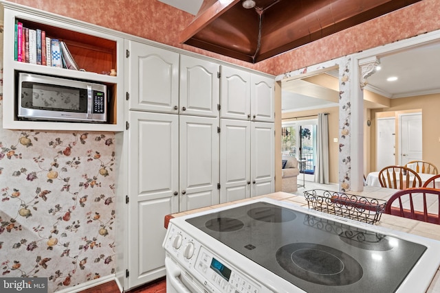 kitchen featuring stainless steel microwave, wallpapered walls, white electric range, and ornamental molding