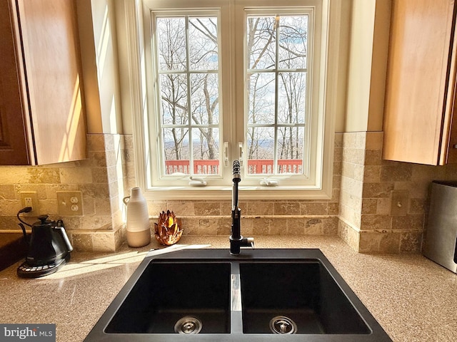 details with tasteful backsplash, light countertops, and a sink