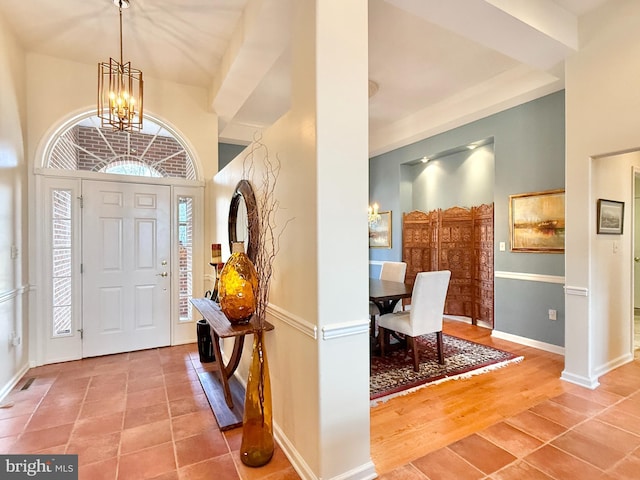 entryway with a chandelier, baseboards, light wood-style floors, and a wealth of natural light