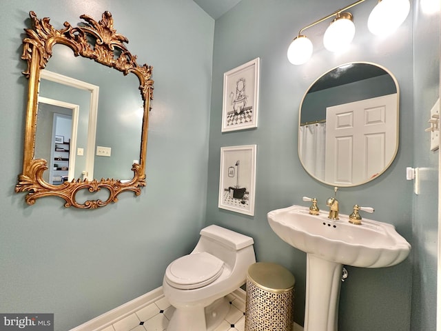 bathroom with toilet and baseboards