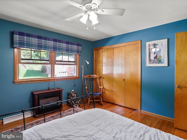 731 Fayette St, Cumberland, MD 21502 - bedroom with baseboard heating, a closet, baseboards, ceiling fan, and wood finished floors