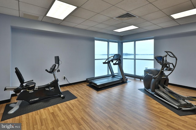 exercise room featuring wood finished floors, visible vents, and baseboards