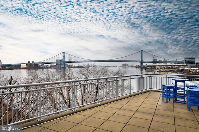 view of patio featuring a city view, a balcony, and a water view