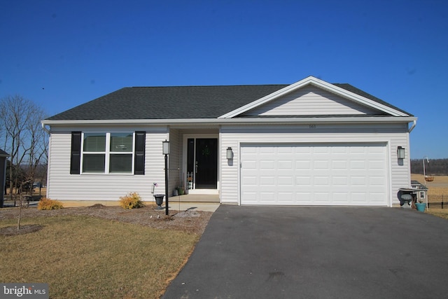 ranch-style home featuring a garage, driveway, and roof with shingles