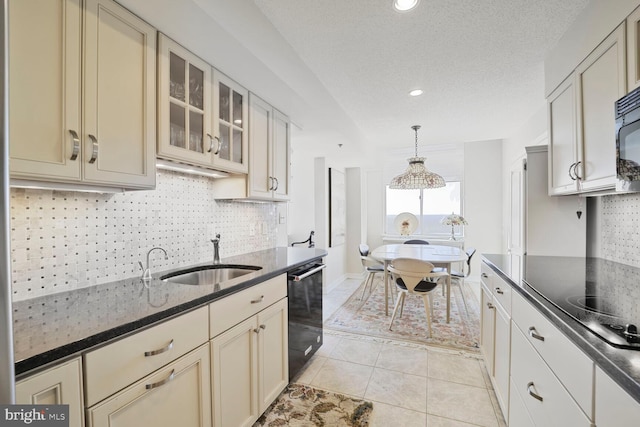 kitchen with a sink, cream cabinetry, and black dishwasher