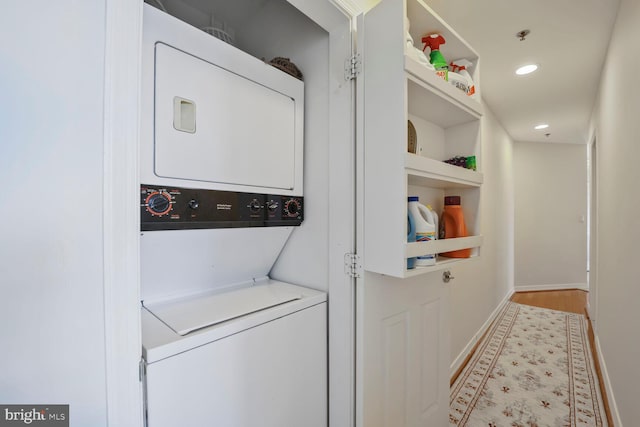 clothes washing area with laundry area, stacked washer / dryer, recessed lighting, and baseboards