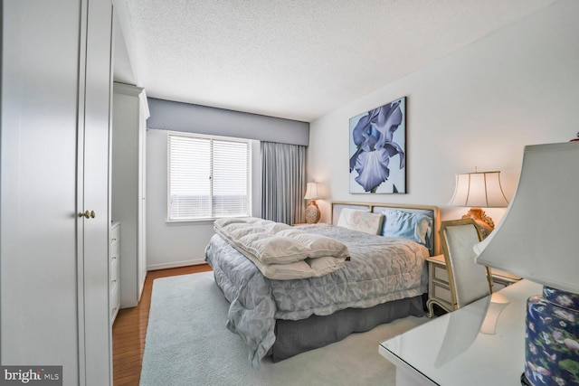 bedroom featuring wood finished floors and a textured ceiling