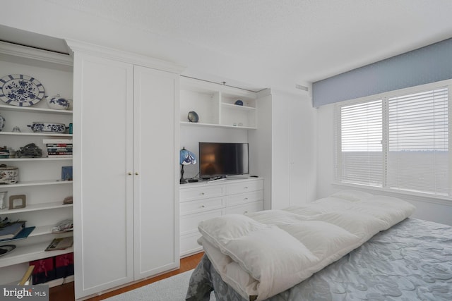 bedroom with wood finished floors and a textured ceiling