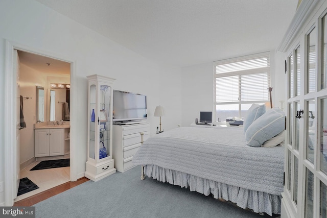 bedroom with connected bathroom, french doors, and a sink