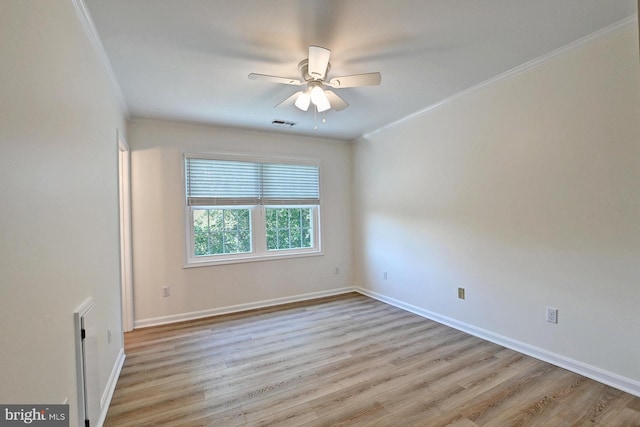 spare room with visible vents, ceiling fan, baseboards, ornamental molding, and wood finished floors