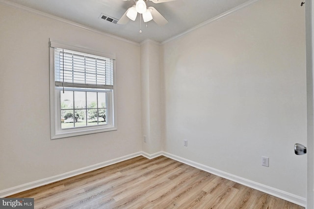 unfurnished room with visible vents, wood finished floors, baseboards, and ornamental molding