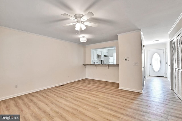 unfurnished living room featuring visible vents, baseboards, light wood finished floors, ceiling fan, and ornamental molding