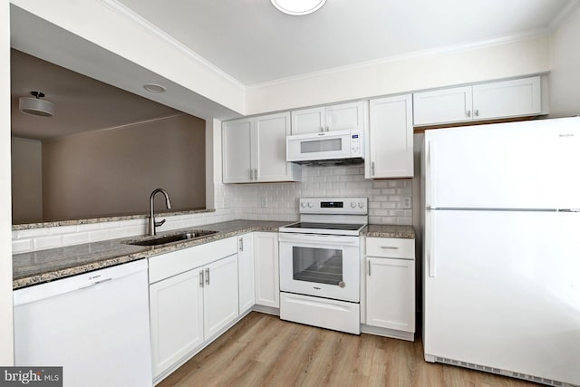 kitchen with a sink, white appliances, backsplash, and ornamental molding