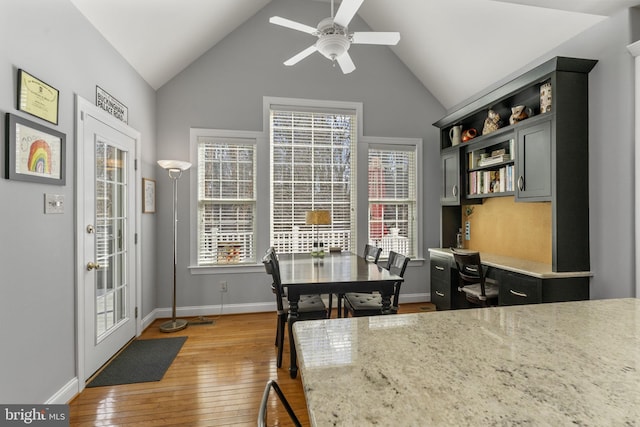 dining space featuring light wood-type flooring, a ceiling fan, french doors, baseboards, and vaulted ceiling