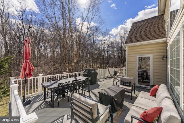 wooden terrace featuring outdoor dining space and an outdoor hangout area