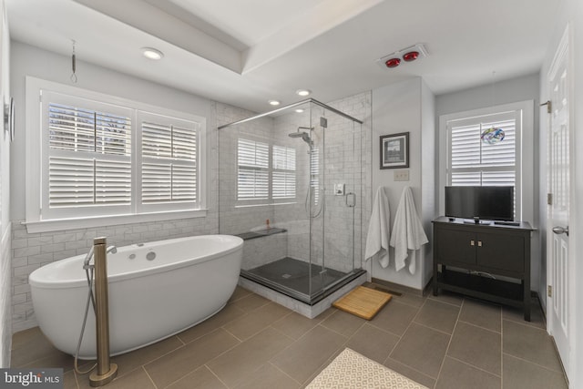 bathroom featuring tile patterned floors, recessed lighting, a stall shower, and a freestanding tub